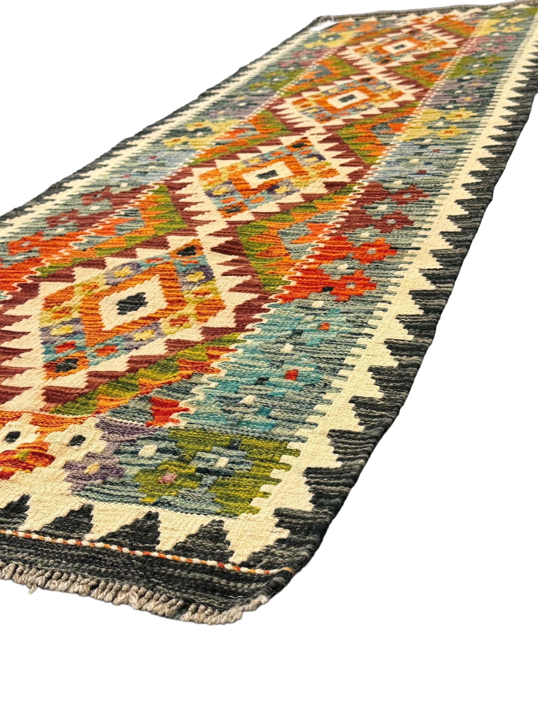 Chobi kilim multi-colour ground runner, the field decorated with lozenges and geometric patterns, within hooked border 
