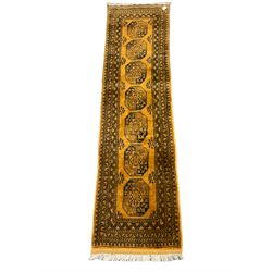 Afghan Bokhara gold ground runner, decorated with seven Gul medallions, six band border with repeating geometric pattern 