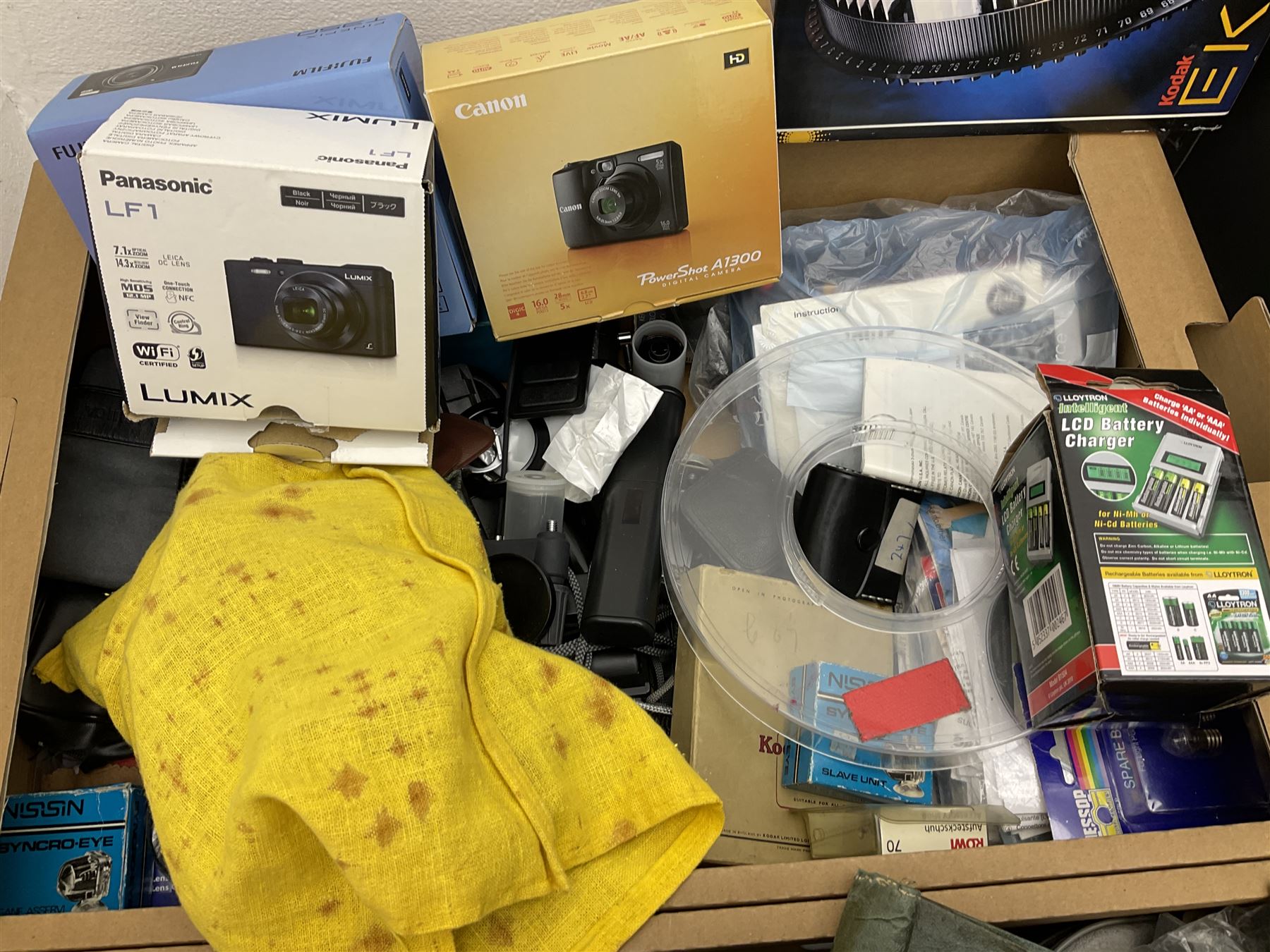 Large quantity of camera equipment in three boxes - Lumix GX1 camera, Canon EOS 500 camera, Lumix FZ100 camera, Pantax  MZ5n, various other cameras, Swift spotting Scope 20 x 60 in box,  Maxtor hard drive, three tripods, Kodak carousel projector, Pradolux slide projector, a selection of camera bags and other camera equipment. 