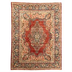 West-Central Persian Mahal hand-knotted carpet, terracotta field with a large central indigo and ivory medallion with floral palmettes and scrolling vines, framed by ivory spandrels with dense foliage within a broad navy border of lotus and palmette motifs linked by scrolling tendrils and multiple guard stripes 