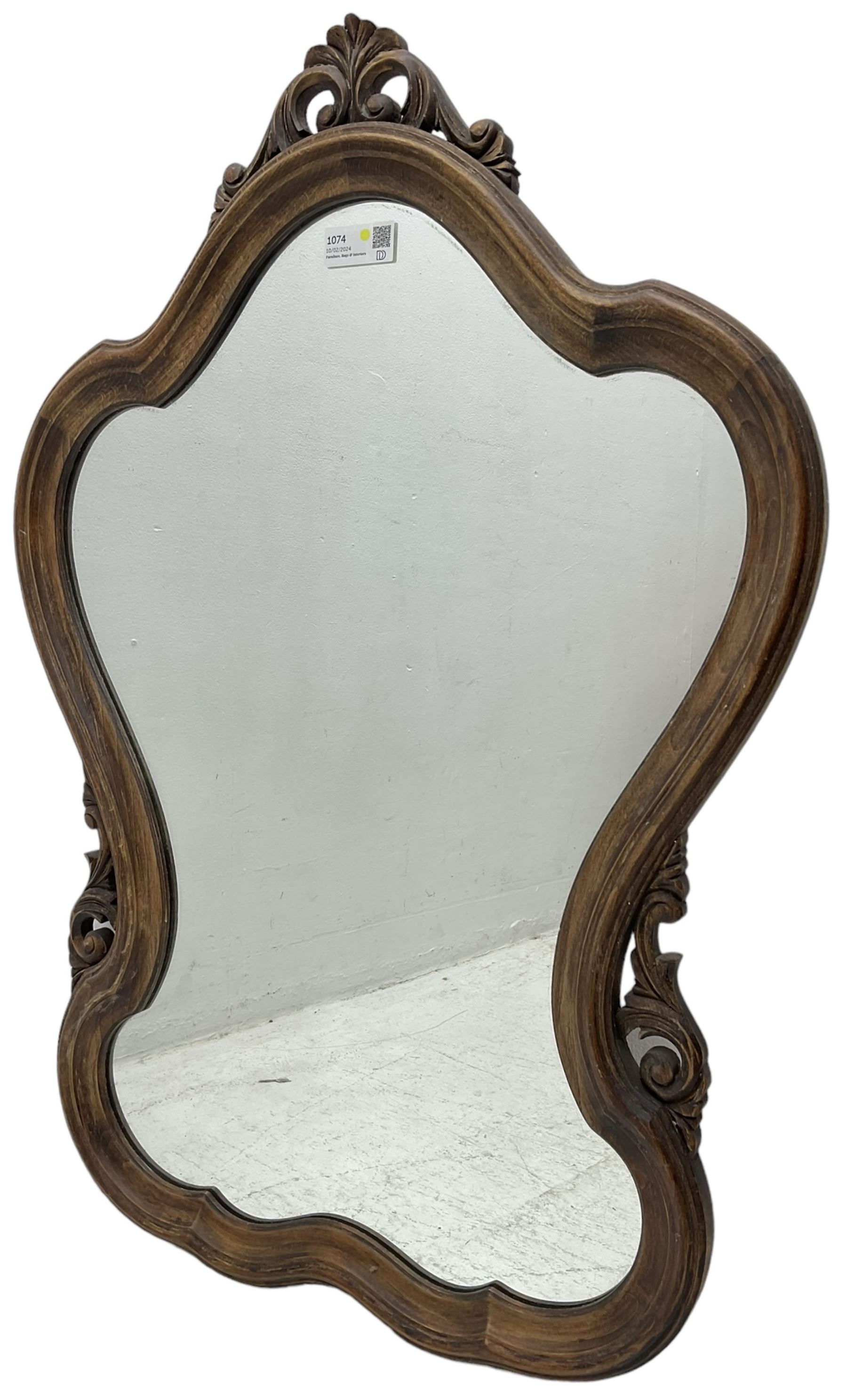 French design stained beech framed wall mirror, shaped and moulded framed with scrolling foliage carved pediment and brackets, plain mirror plate 