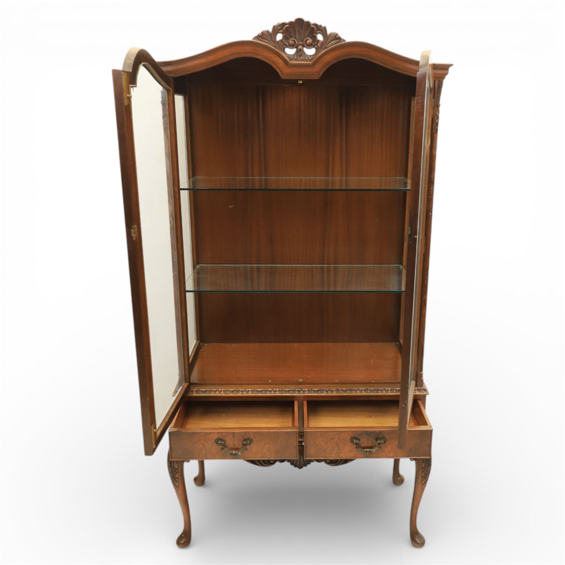 Queen Anne design walnut display cabinet, carved cartouche above two glazed doors enclosing two fixed glass shelves, over two frieze drawers above a heavily carved apron with cabriole supports