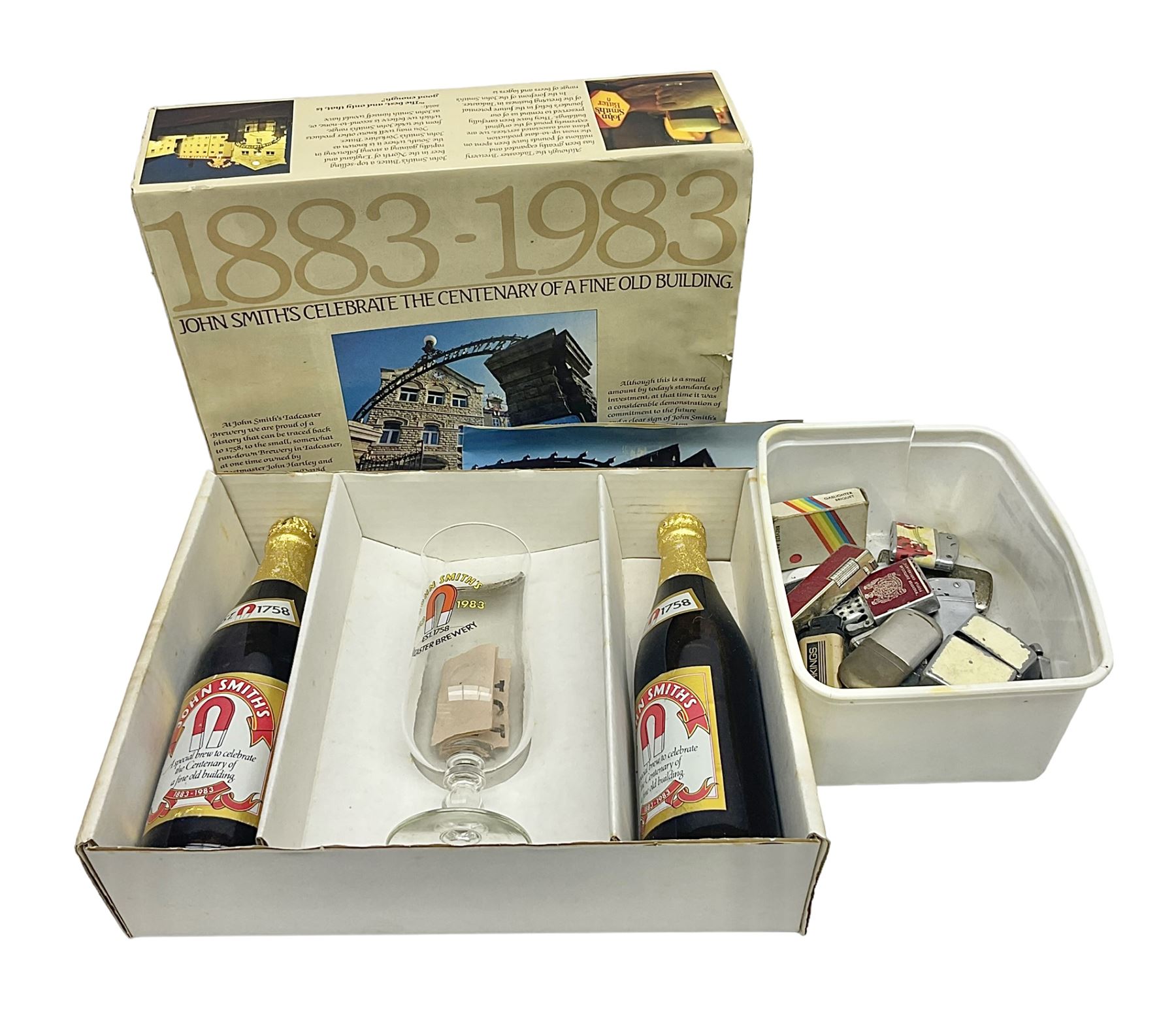 John Smiths presentation box commemorating 100 years of the Tadcaster brewery, containing two bottles of special brew and a glass, and a collection of lighters including Ronson and Jutson