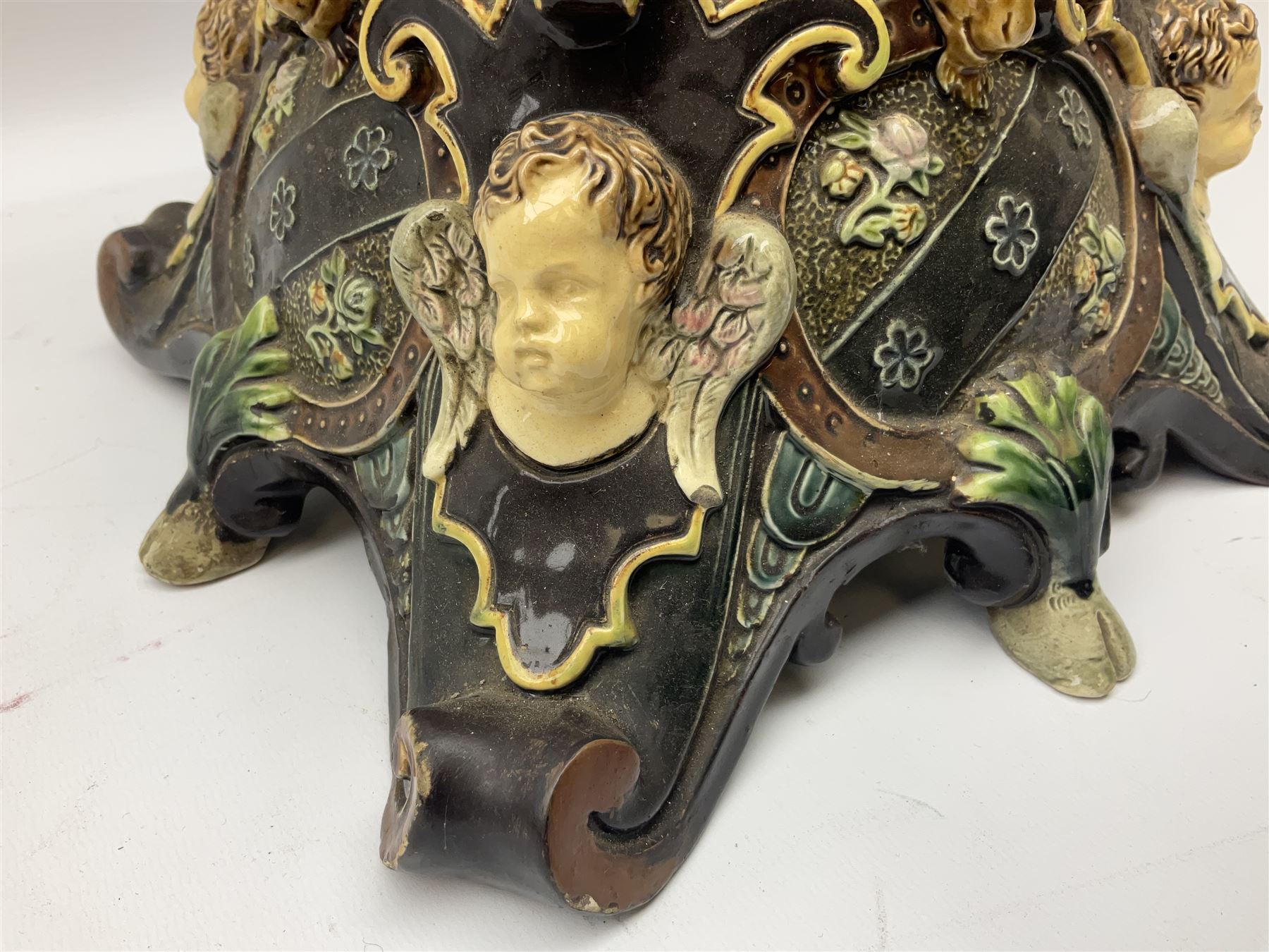 Composite table lamp modelled as a Roman Emperor donning blue robes, upon quatrefoil base modelled with rams heads and winged cherubs, H56cm excl fitting