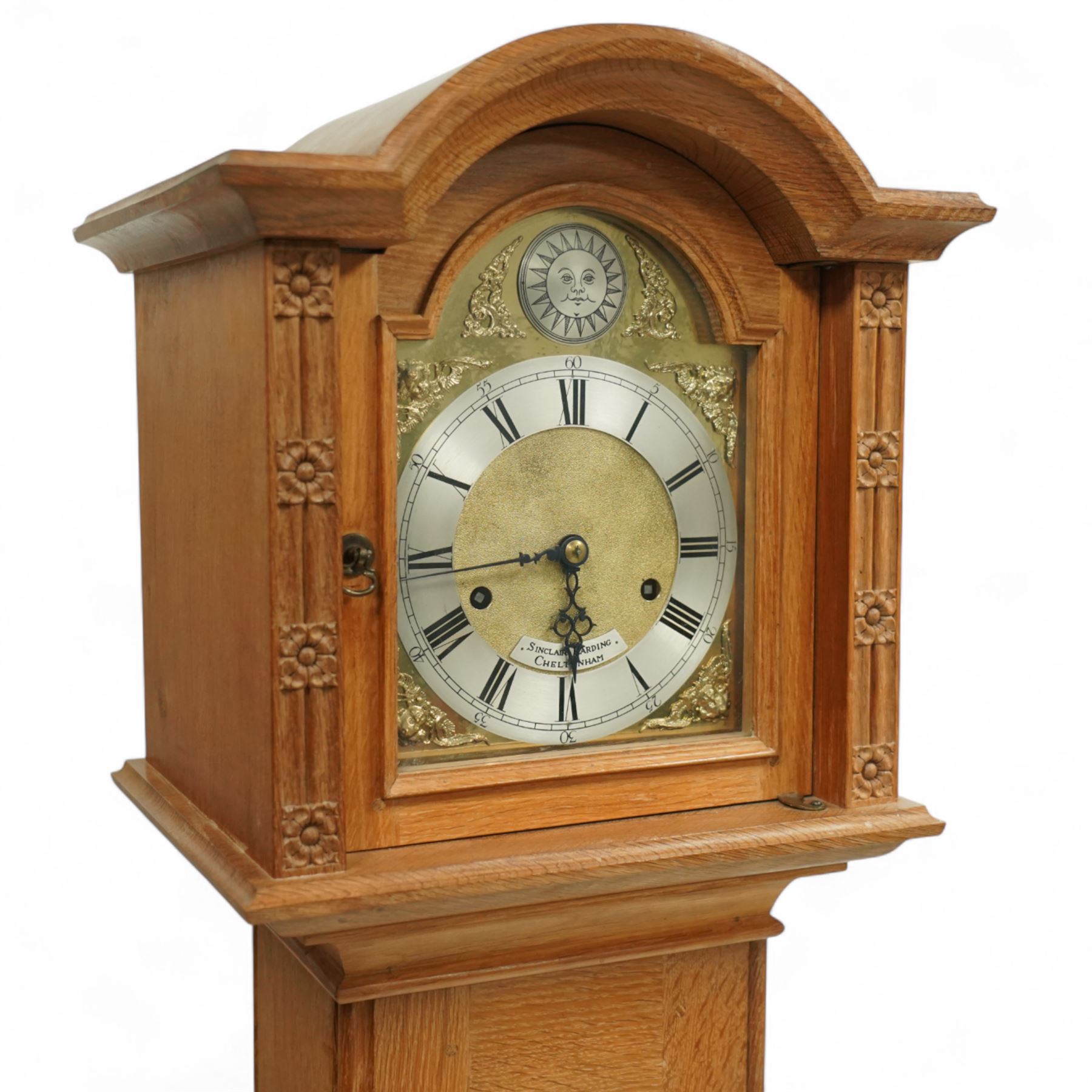 Mouseman - Oak 8-day grandmother clock, with a high quality weight driven movement and dial by Sinclair and Harding & Co of Cheltenham (No 477), brass break-arch dial with pierced steel hands, cast spandrels and a matted dial centre, silvered chapter with Roman numerals and minute track, dial pinned to  a two train rack striking movement, striking the hours on a cast bell, case with a full length glazed door and visible brass cased weights and conforming brass cased cylindrical pendulum. Signature carved mouse to the top of the arch of the case, from the workshop of Robert Thompson of Kilburn
With key.
Longcase.