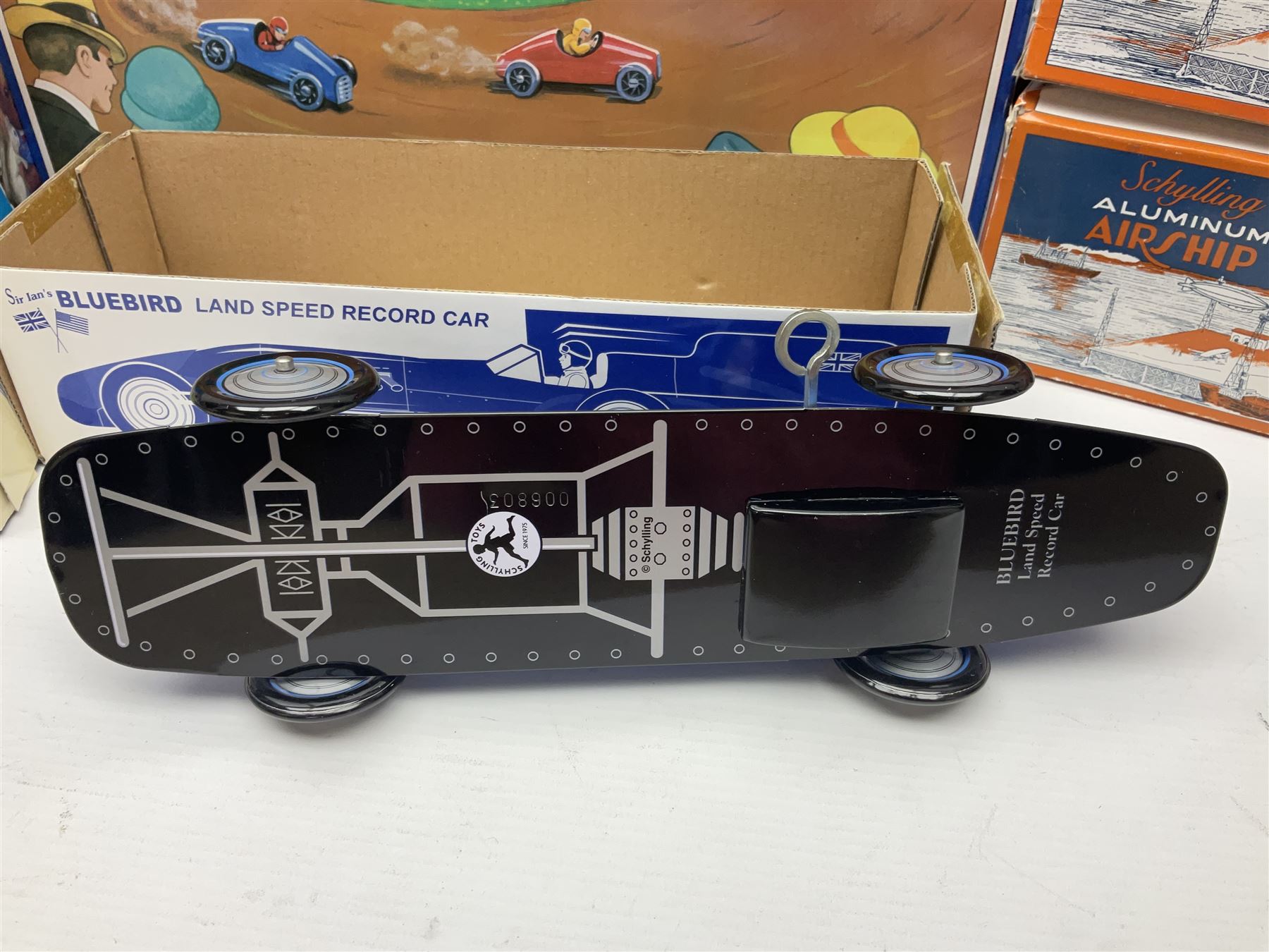 Schylling - six tinplate models comprising Sir Ian’s Bluebird racing car, Speedway Auto Racer, two Aluminium Airships, Tin Speedboat and Ernest in the Music Box; all in original boxes 