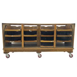 Early 20th century oak framed and glazed haberdashery / shop display cabinet, fitted with sixteen drawers (three missing), on later casters
