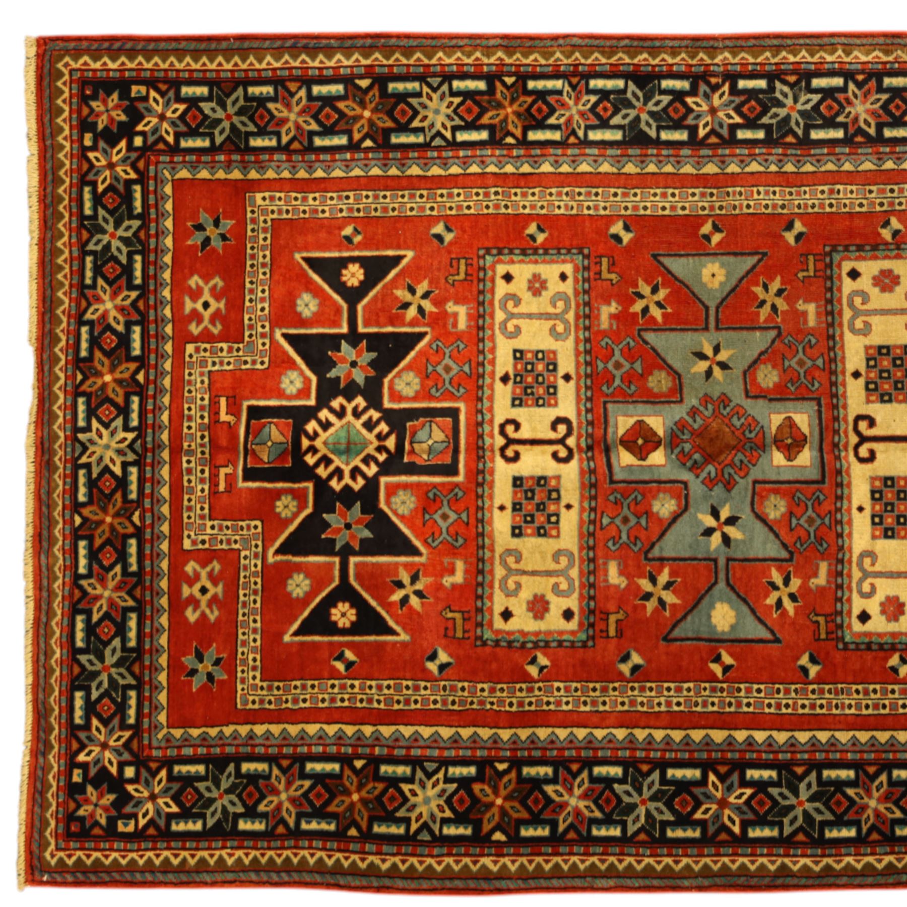 North West Persian Ardebil rug, three-medallion design with central octagonal starburst medallion flanked by two cruciform cartouche-style medallions, main field in terracotta red populated with hooked geometric, zoomorphic shapes and rosettes, main border with a series of eight pointed stars in alternating tones on a dark navy ground, separated by small diamonds and geometric fillers, inner and outer guard stripes with a classic reciprocal sawtooth motif 