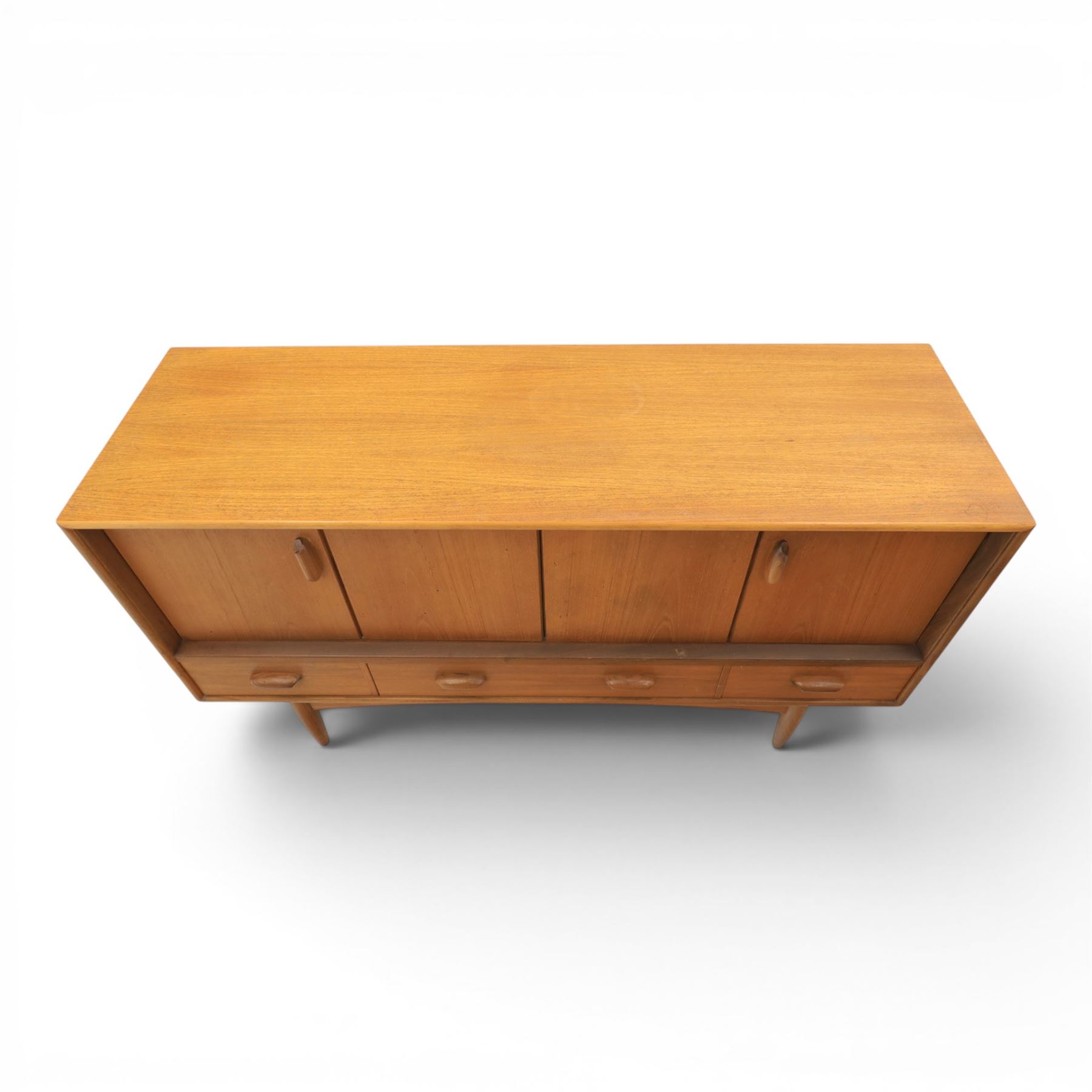 G-Plan - 'Brasilia' teak sideboard, with rectangular top above two concertina doors, above four drawers raised on cylindrical supports