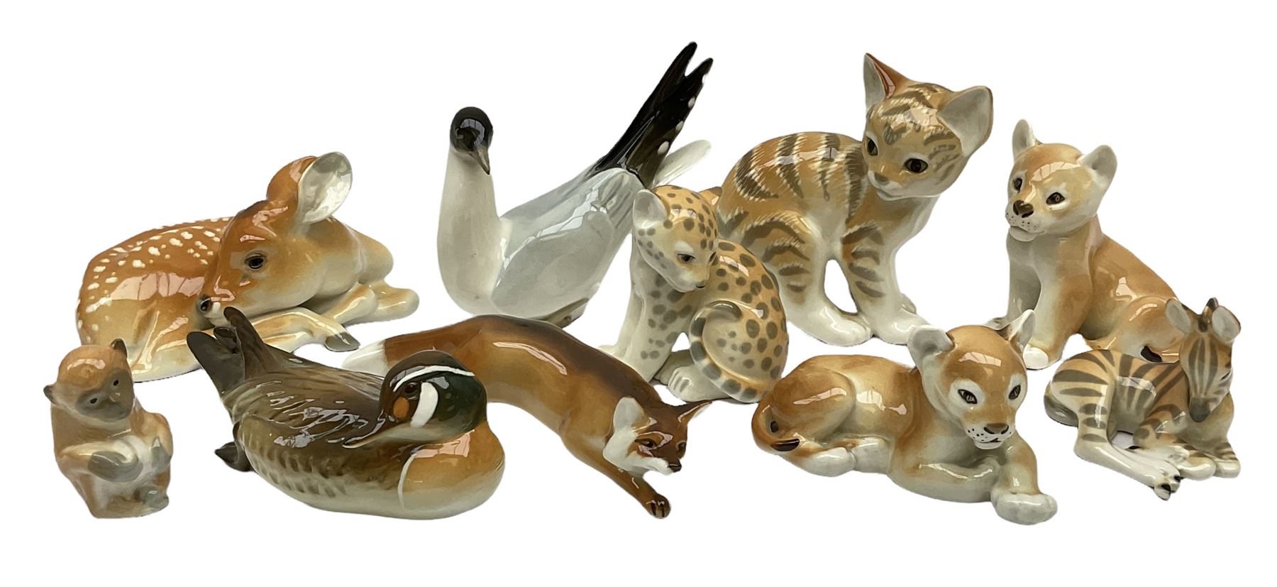 Group of Russian USSR animal figures by Lomonosov, to include examples modelled as an outstretched hunting fox, kitten, lion cubs, seagull/tern etc, all with stamped marks beneath, together with a model of a recumbent deer with no marks, tallest H14cm