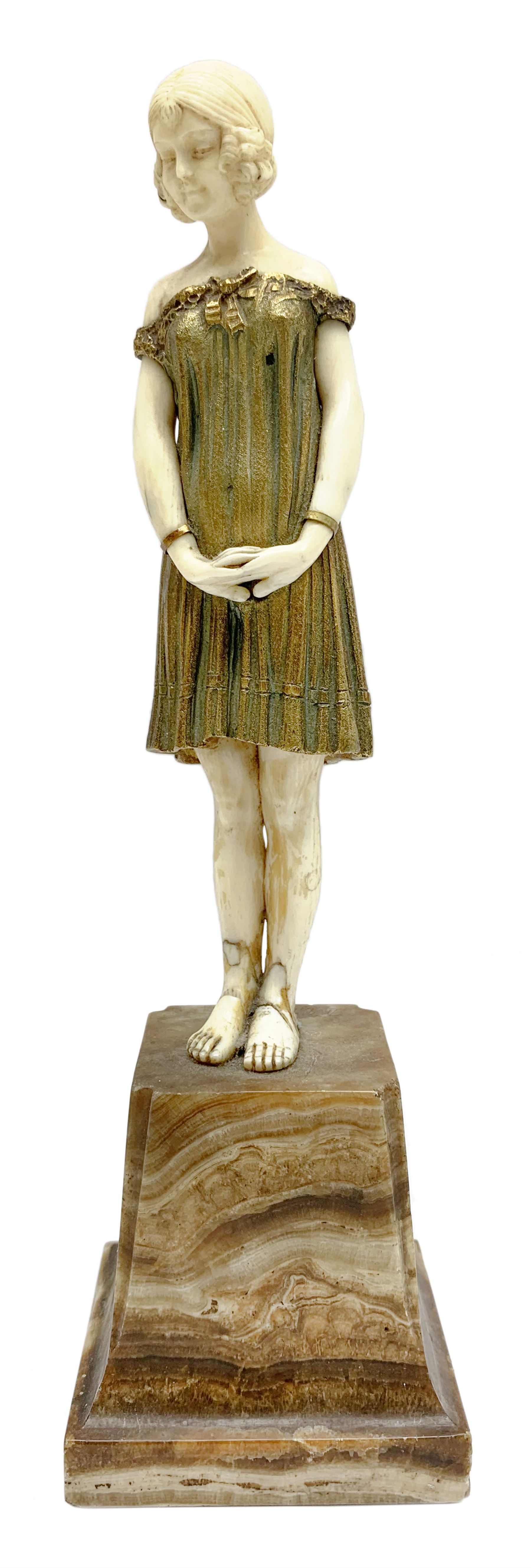 Demetre Chiparus (1886-1947): Innocence, a gilt bronze and ivory figure, circa 1925, standing in contemplative post with hands clasped, upon onyx plinth, signed to base, H24.4cm
