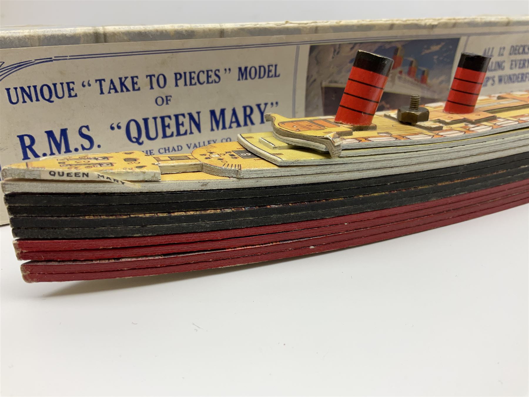 Chad Valley 'Take to Pieces' model of R.M.S. Queen Mary; made up of thirteen removable decks revealing the interior, held together by nuts/bolts to the top deck; boxed with original key chart sheet