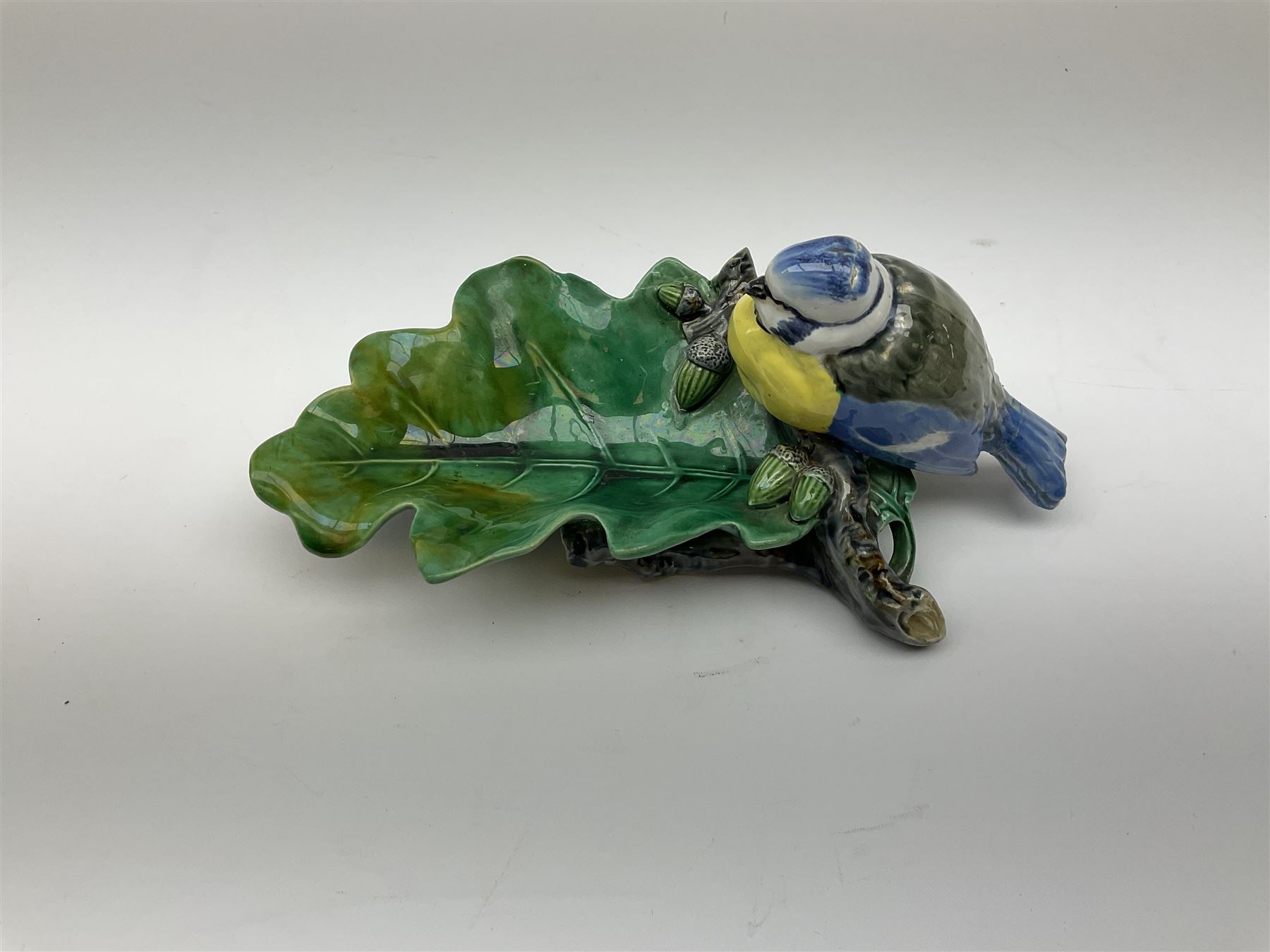 Minton majolica leaf dish, modelled as a Blue Tit perched on a branch with acorns and an oak leaf, date cypher for 1868, impressed marks beneath, L21cm. 