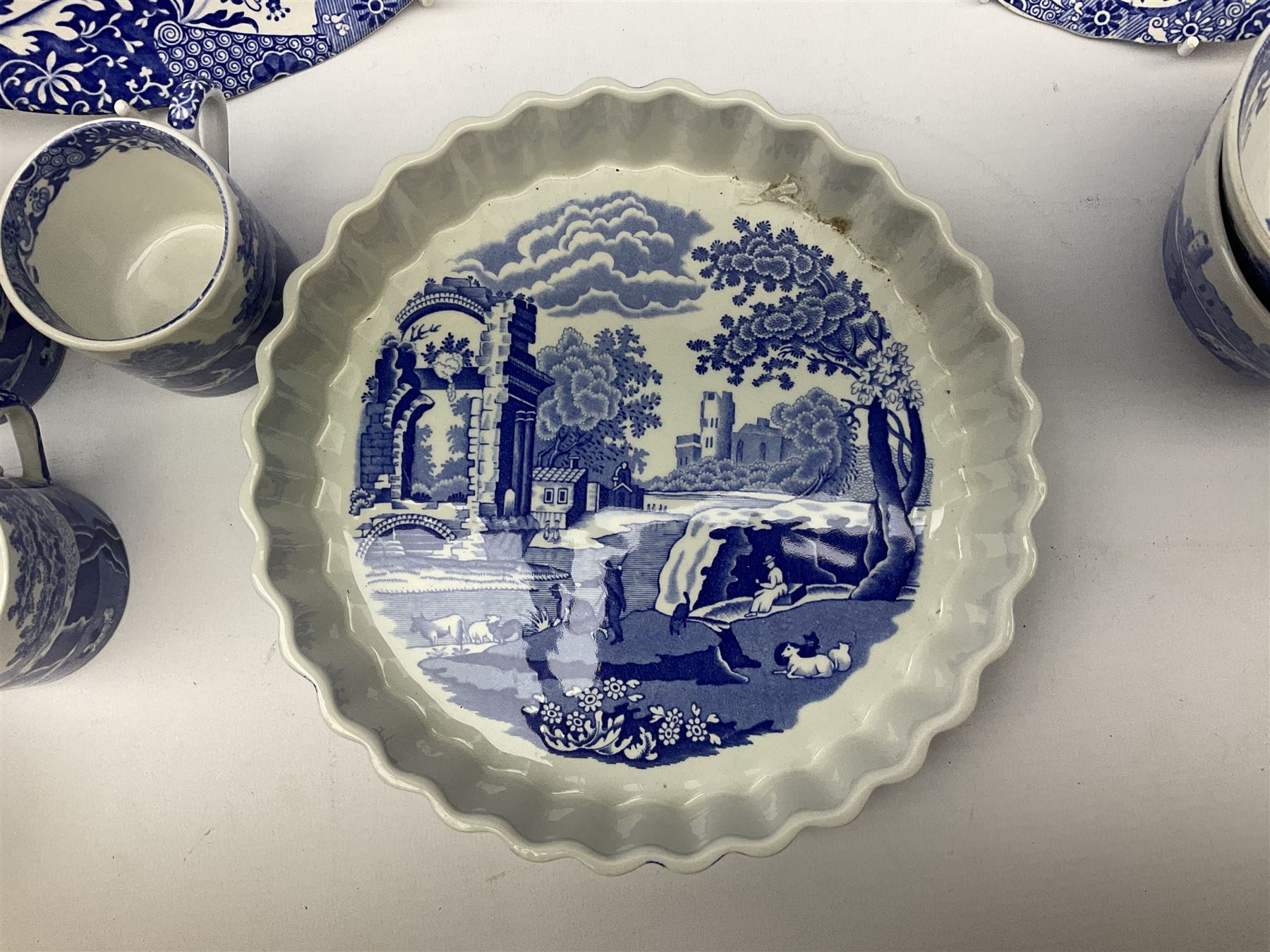 Spode blue and white Italian pattern dinner and tea wares, comprising five dinner plates, four side plates, seventeen side plates, four bowls, ten tea cups and twenty one saucers, five coffee cans and six saucers, and a flan dish, with blue and black printed marks beneath 