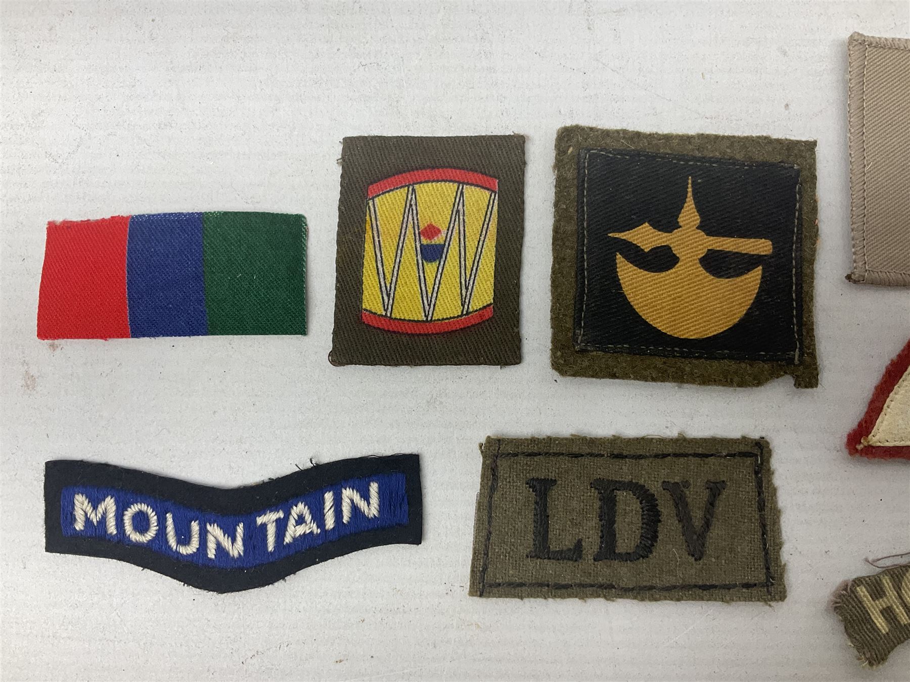Royal Arms cloth arm adge as worn by Regimental Serjeant-Majors in Foot Guards; naval cap badge; WW2 Commando/Special Forces cloth badges; Home Guard and LDV shoulder titles; and other cloth badges including armoured division, 45th and 77th division, 52nd Lowland Mountain division etc; and 24th Infantry Brigade airmobile pennant