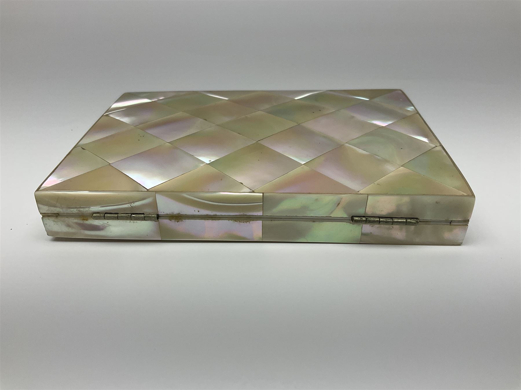 Victorian mother of pearl tea caddy, of rectangular bow-fronted form, the body with floral, bird and geometric engraved mother of pearl panels, white metal shield plaque to the cover inscribed with the initials G.J.A and similar escutcheon, the two division interior with ivory edging and two panelled mother of pearl lids, on four vegetable ivory bun feet L20cm, together with a similar style mother of pearl card case (2) This item has been registered for sale under Section 10 of the APHA Ivory Act