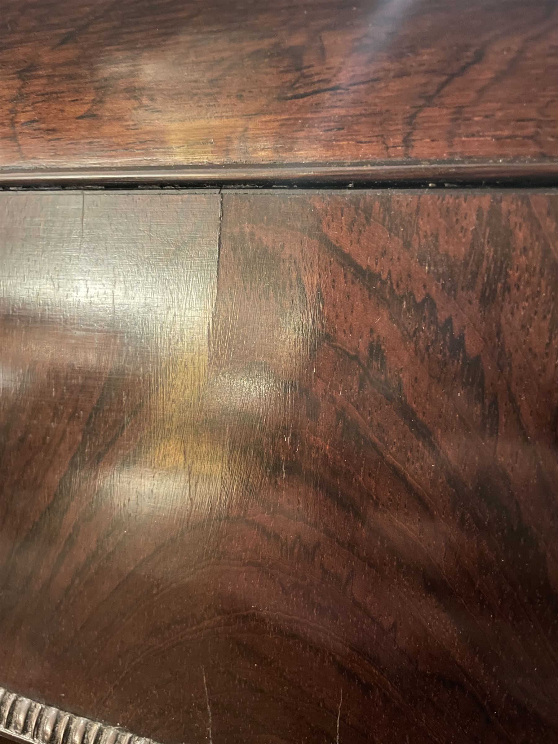 Early 19th century rosewood and brass inlaid tea caddy, of sarcophagus form, the front and hinged opening cover inlaid with brass scrolling panels, opening to reveal a compartmented interior with twin removable boxes with conforming inlaid brass detail to the hinged covers and zinc lining to the interiors, flanking a later glass mixing bowl, the whole upon four turned cylindrical feet, H21cm W36cm D20cm