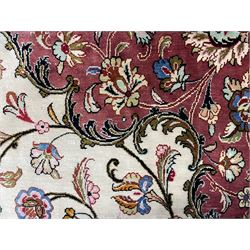 Finely knotted Persian Qom silk rug, overall pink ground with ivory field, the field with central cusped medallion profusely decorated with interlacing foliate and stylised flower heads, multiple band boarder, the main band decorated with a series of stylised motifs and trailing foliage, the outer guard with signature panel 