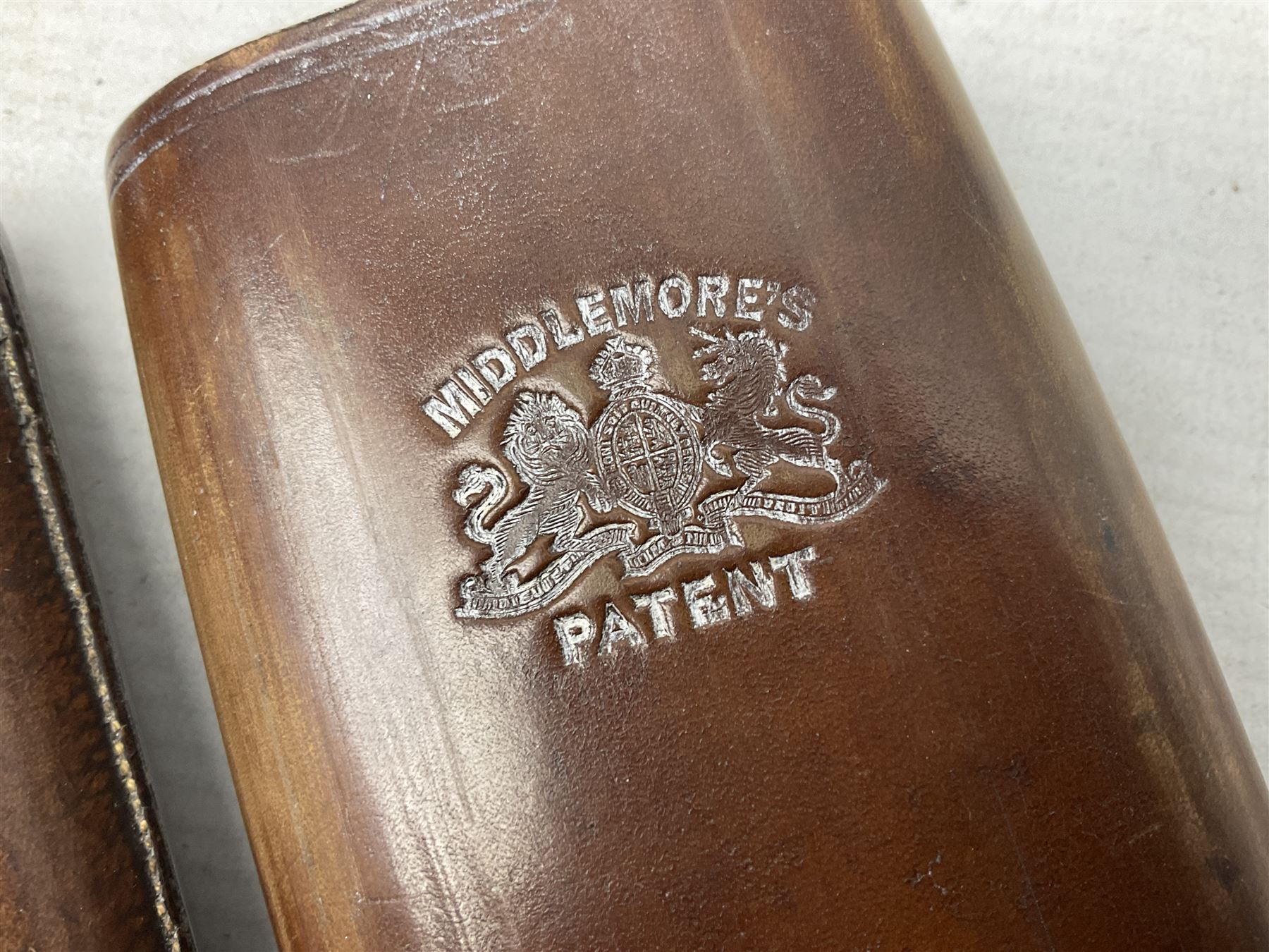 Victorian leather cigar protector with metal match striking plate on the end and internal spring to hold the cigars in place; expands for differing lengths of cigar, minimum L12.5cm; another similar leather cigar case marked Middlemore's Patent with attached vesta case and striker; three Bryant & Mays tin-late matchbox holders including 1935 Jubilee; and small box of matches (6)