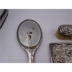 Group of silver, to include Edwardian dressing table tray, embossed with irises and a a matching clothes brush, both hallmarked Charles Henry Dumenil, London 1904 & 1905, together with a three piece silver mounted dressing table set, including hand mirror, hair brush and comb, the brush and mirror embossed with female figure amongst flowers to reverse, all hallmarked Henry Matthews, Birmingham 1910 & 1917, tray L22.5cm