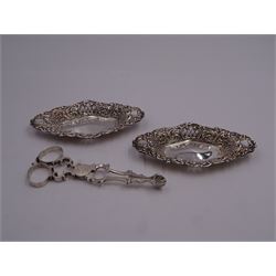 Small pair of Victorian silver trinket dishes, each of lozenge form with pierced sides and C scroll rim, hallmarked Walter & John Barnard, London 1895, L11.5cm, together with a pair of Georgian silver scissor action sugar nips with shell shaped bowls, possibly late George II or early George III, makers mark H.P, probably for Henry Plumpton, approximate total weight 2.49 ozt (77.7 grams)