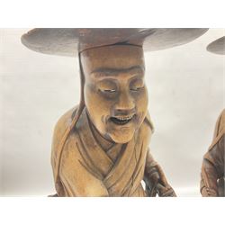 Pair of Japanese carved wooden figures, modelled as merchants in traditional dress, upon pierced naturalistic bases, tallest H39cm