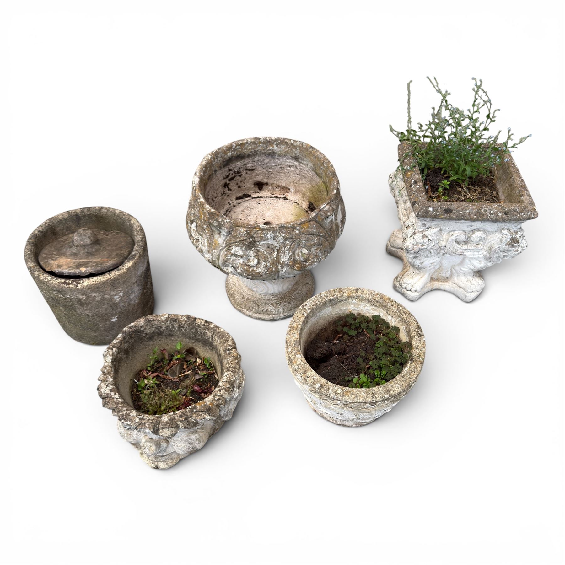 Five composition stone garden planters, comprising various circular and square forms with relief foliate decoration, together with a cylindrical lidded garden pot.