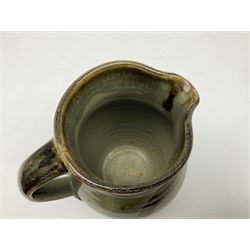 Michael Leach (British 1913-1985) for Yelland pottery; two large glazed stoneware plates with dark brown stylised decoration upon oatmeal ground, together with a jug in merging blue, green and brown, all with impressed marks beneath, largest plate D37cm