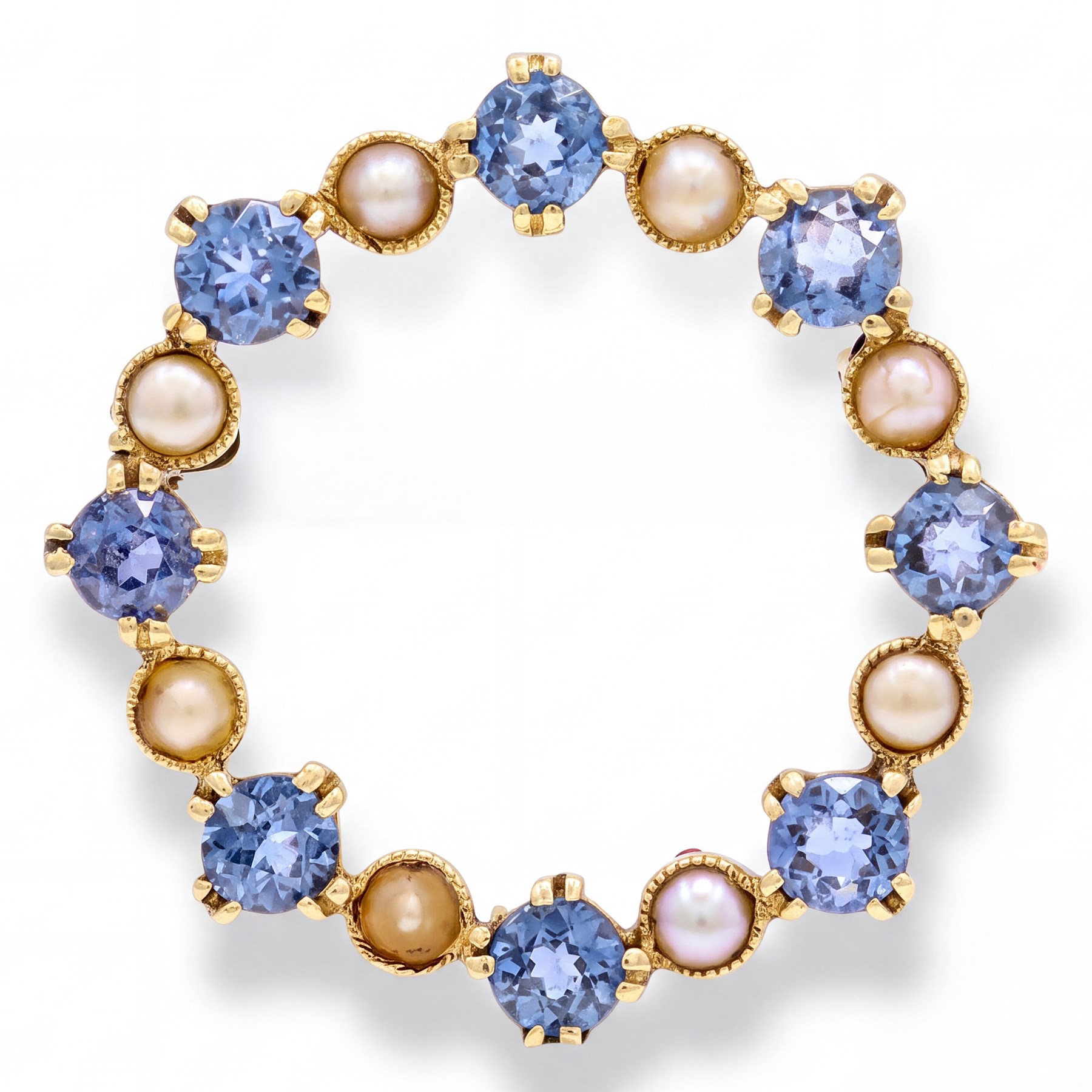 Early 20th century 15ct gold sapphire and pearl circular brooch, set with alternate round cut sapphires and split pearls, stamped 15
