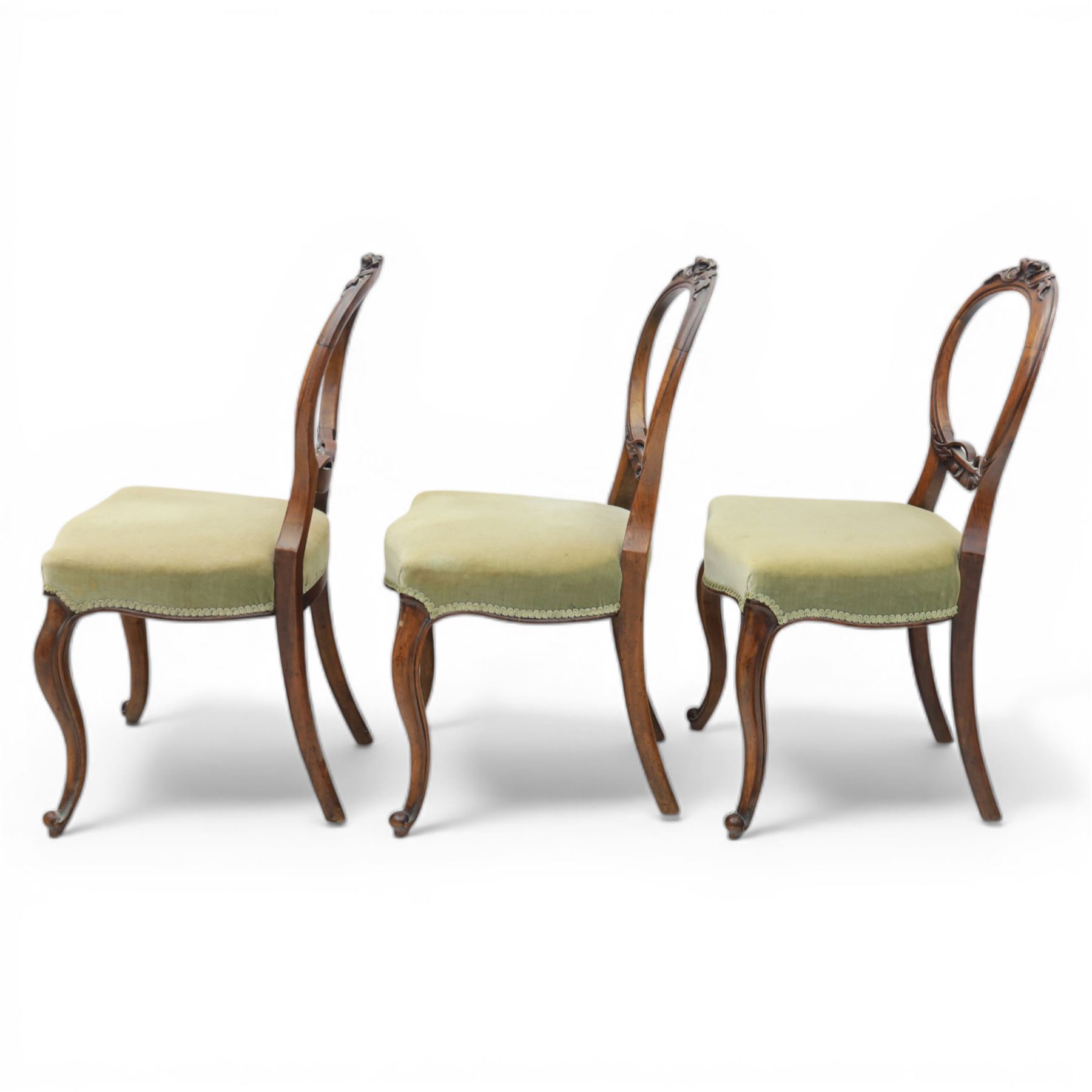 Victorian mahogany dining suite, oval tilt top dining table raised on a quatriform base with paw feet, together with a set of six balloon back dining chairs with green upholstery with cabriole legs 