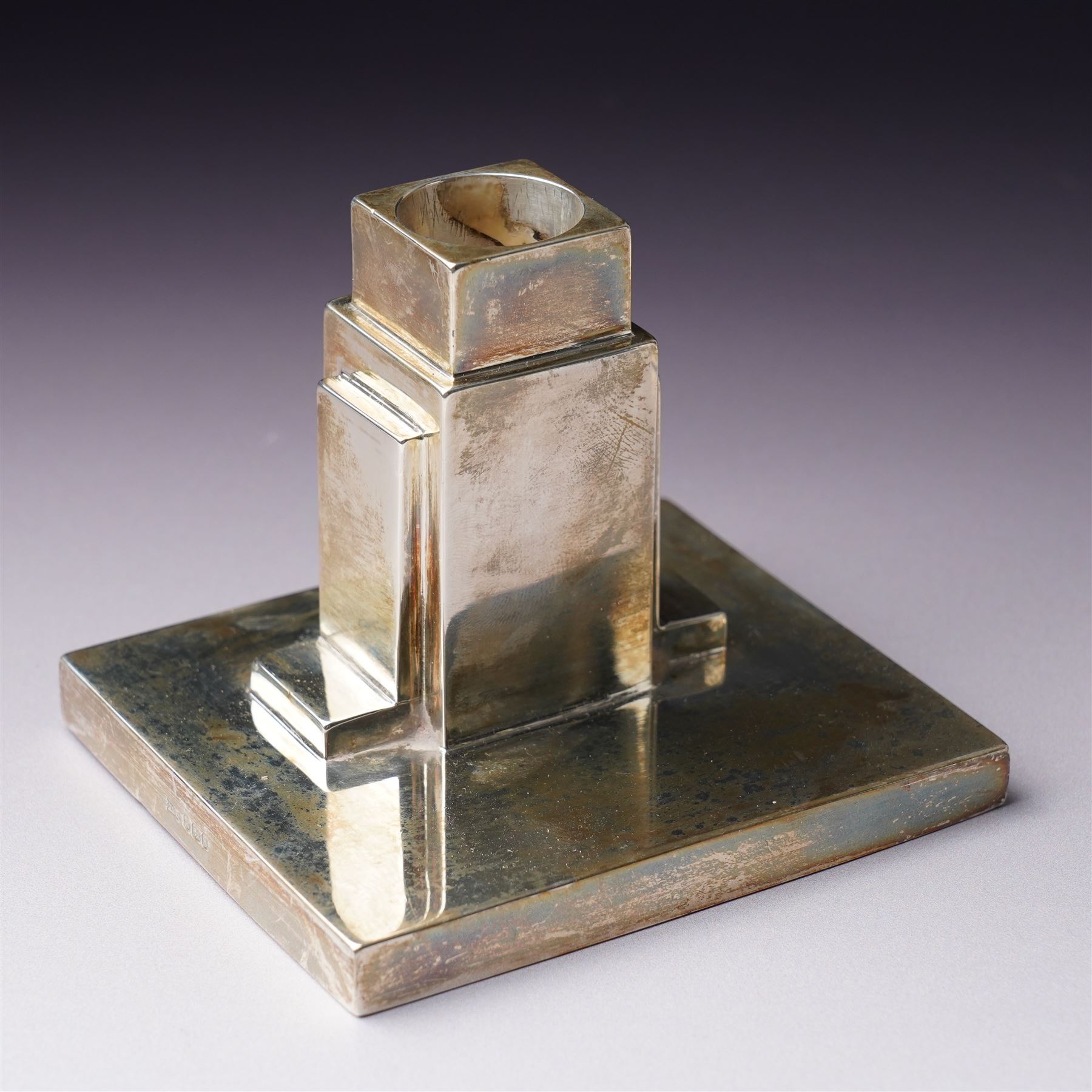 Pair of Art Deco silver candlesticks with square section stems supported by two lappets on a rectangular base H7.5cm x W9.5cm Sheffield 1935 Maker Walker & Hall