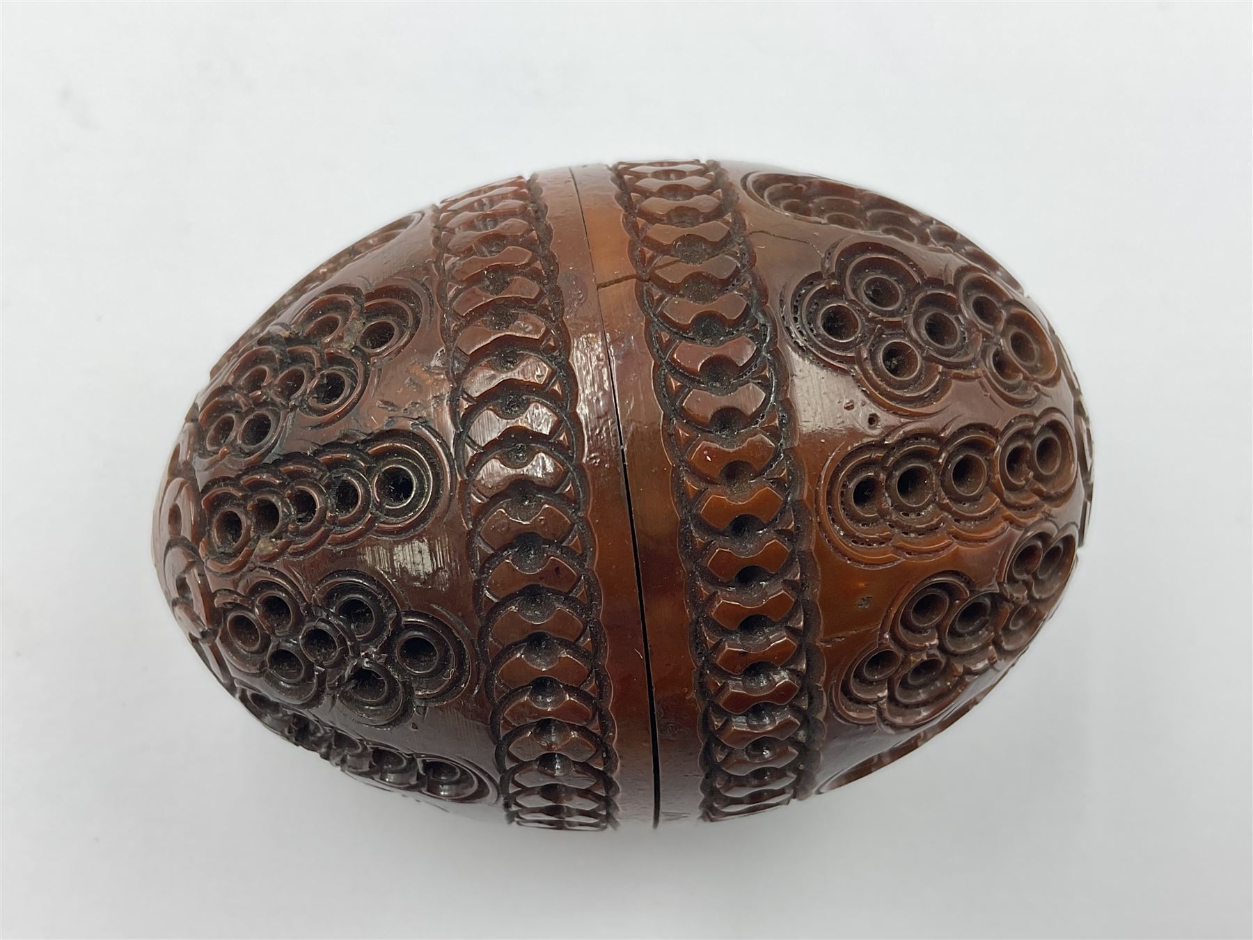 Three 19th century coquilla nut pomanders or flea catchers, two of egg shaped form and the third of barrel from with carved and pierced decoration and screw threaded join, largest H8cm
