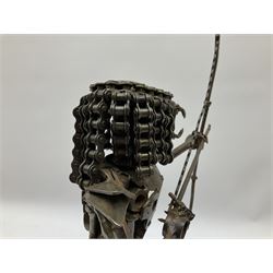 Predator metal sculpture, made with scrap metal, with articulated body, bike chain hair, and bow and arrow, H45cm