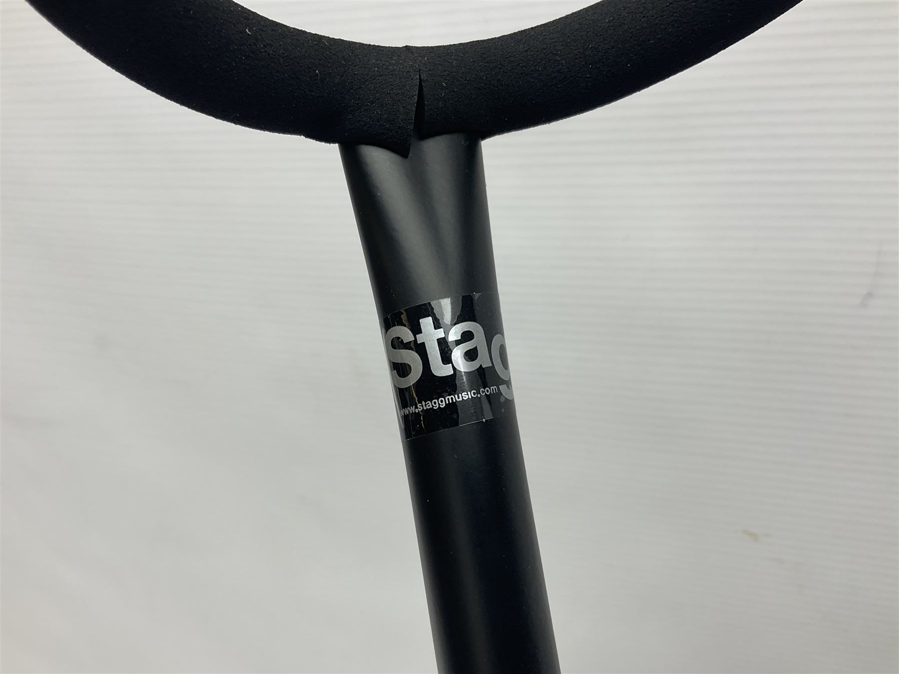 Four folding tubular guitar stands, two by RockJam; and folding tubular saxophone stand (5)