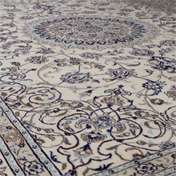 Central Persian Nain hand-knotted carpet, wool with silk highlights, ivory field with central radiating medallion surround by an intricate arrangement of scrolling vines and floral motifs, within conforming spandrels and matching border, cotton fringe ends 
