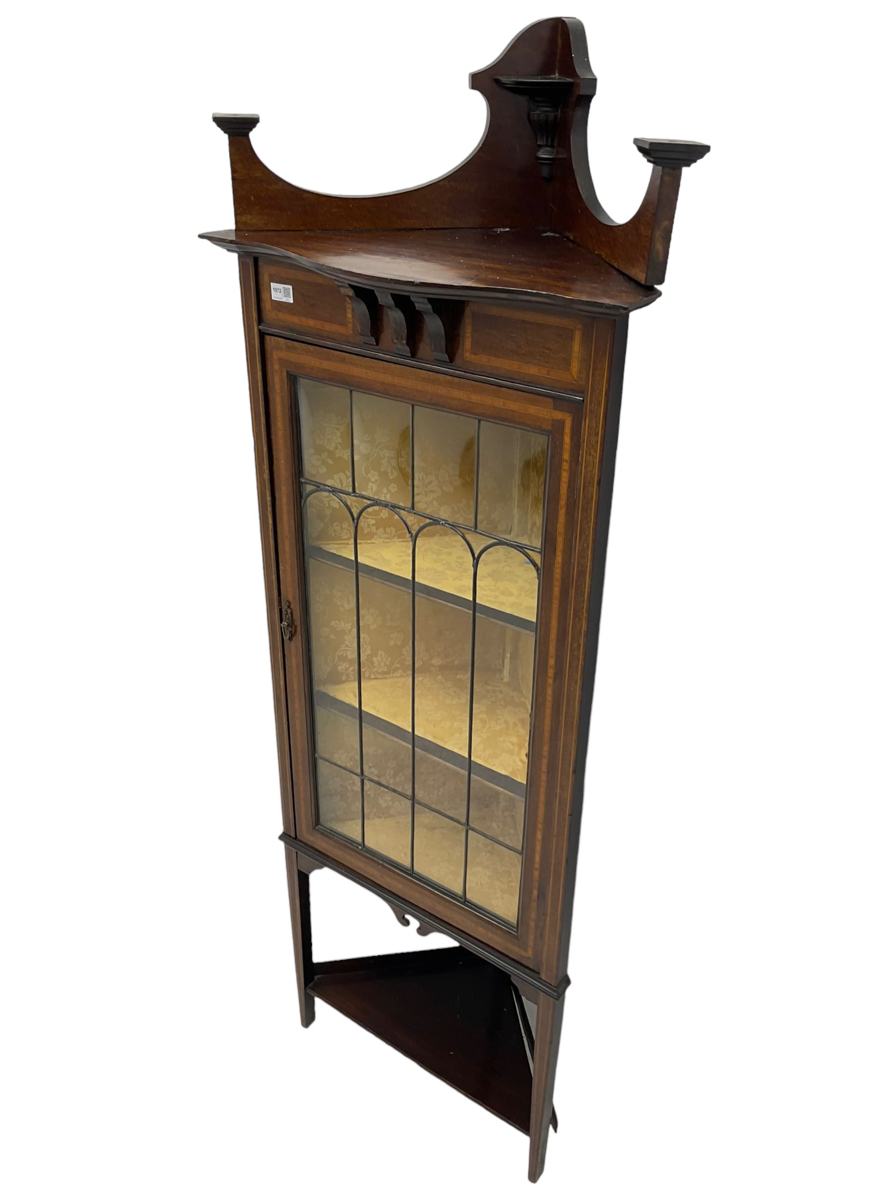 Edwardian inlaid mahogany corner cabinet, fitted with single astragal glazed door enclosing two shelves, flanked by satinwood banding, on square tapering supports united by undertier