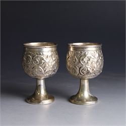 Pair of miniature Indian silver goblets, with embossed floral and foliate decoration, H6.5cm
