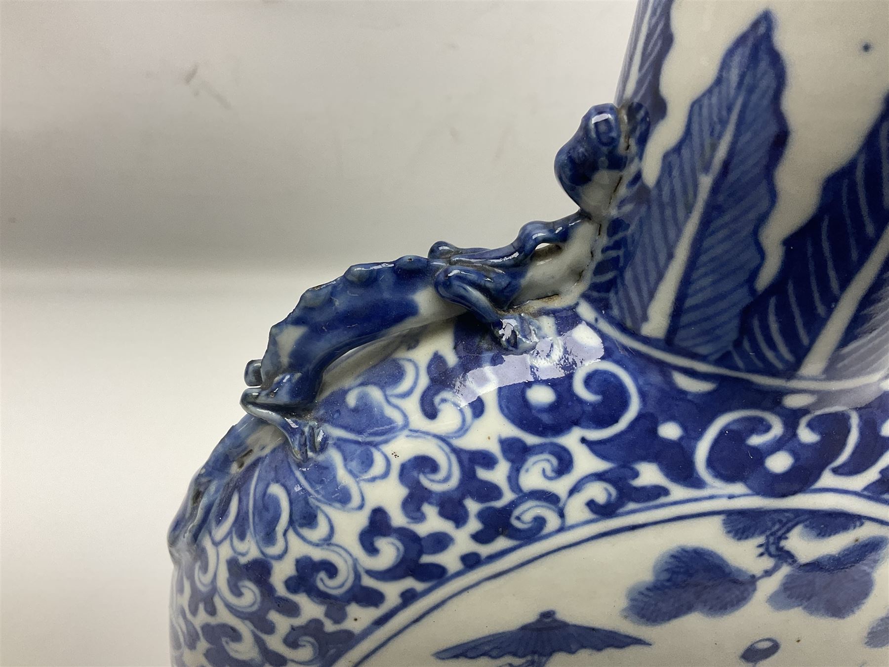 19th century Chinese blue and white moon flask vase, the central panel depicting musicians, bordered by floral, foliate and scroll decoration, with lizard handles to each shoulder, upon an oval foot, H31cm 