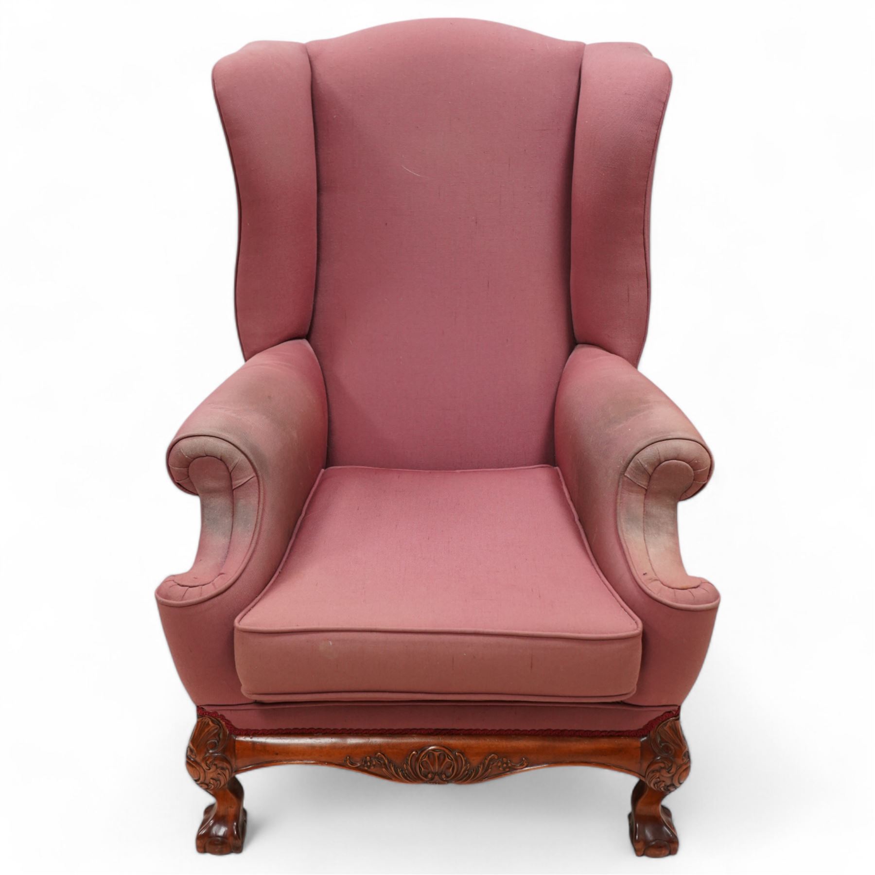 Georgian design mahogany framed wingback armchair, upholstered in rouge fabric, on ball and claw feet with foliate cartouche decoration 