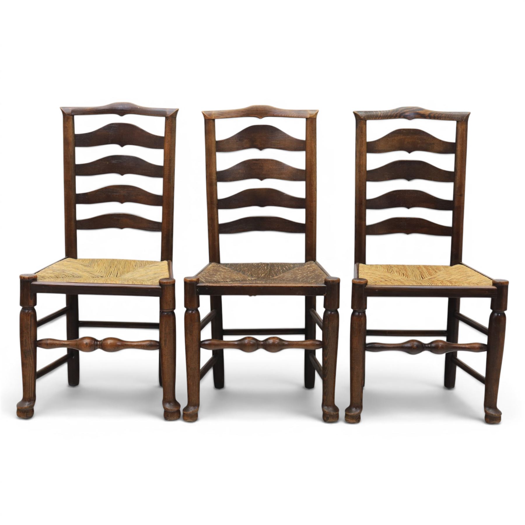 Set of seven (6+1) Georgian design country elm Lancashire dining chairs, ladder backs with rush seats, turned front leg stretcher on pad feet, height of seat 44cm, complete with fitted tie on cushions