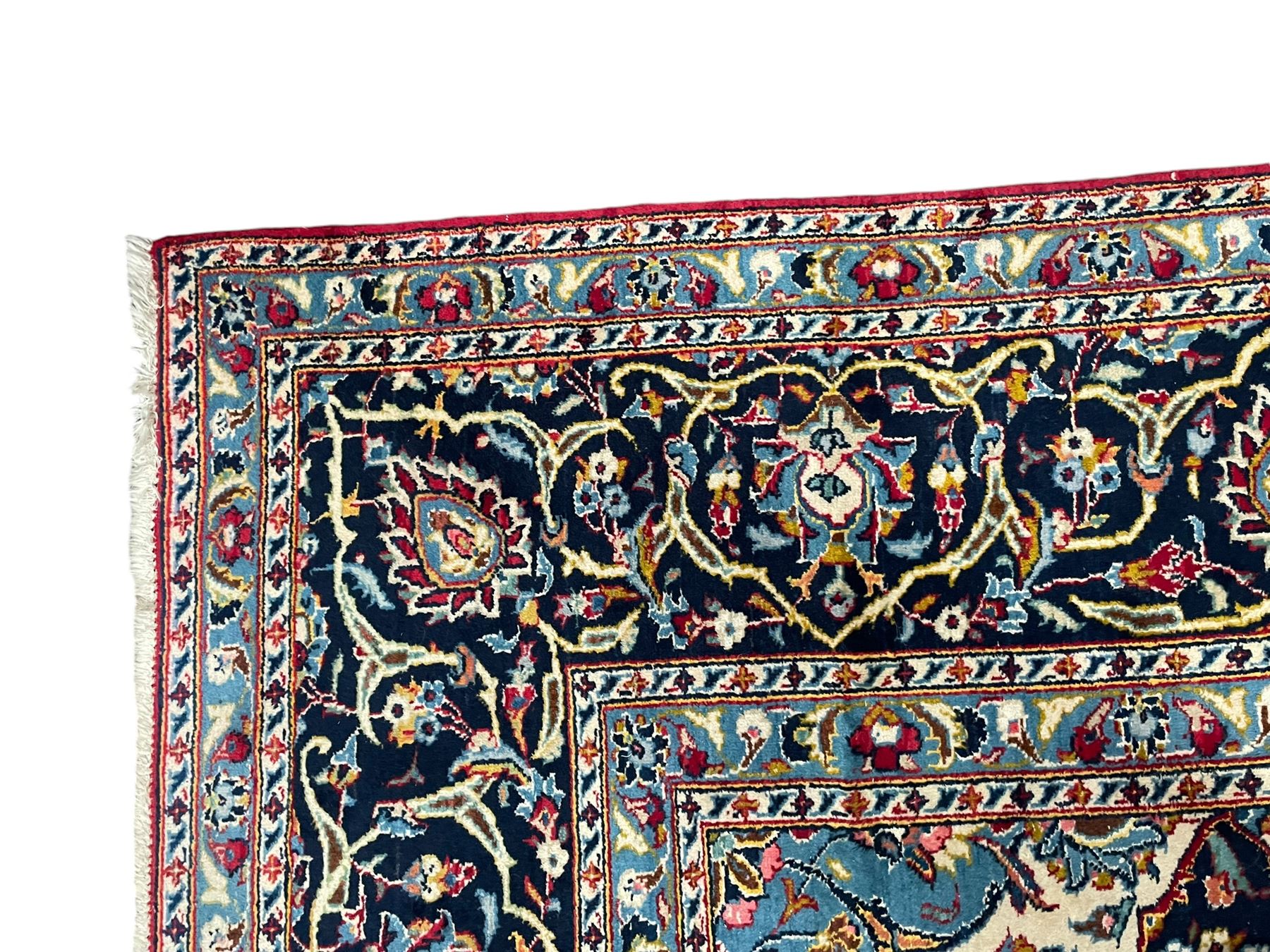 Persian Kashan crimson ground carpet, the central pole medallion decorated with flower heads, surrounded by trailing leafy branches and palmettes, scrolling border decorated with further palmettes, within floral pattern guard stripes 