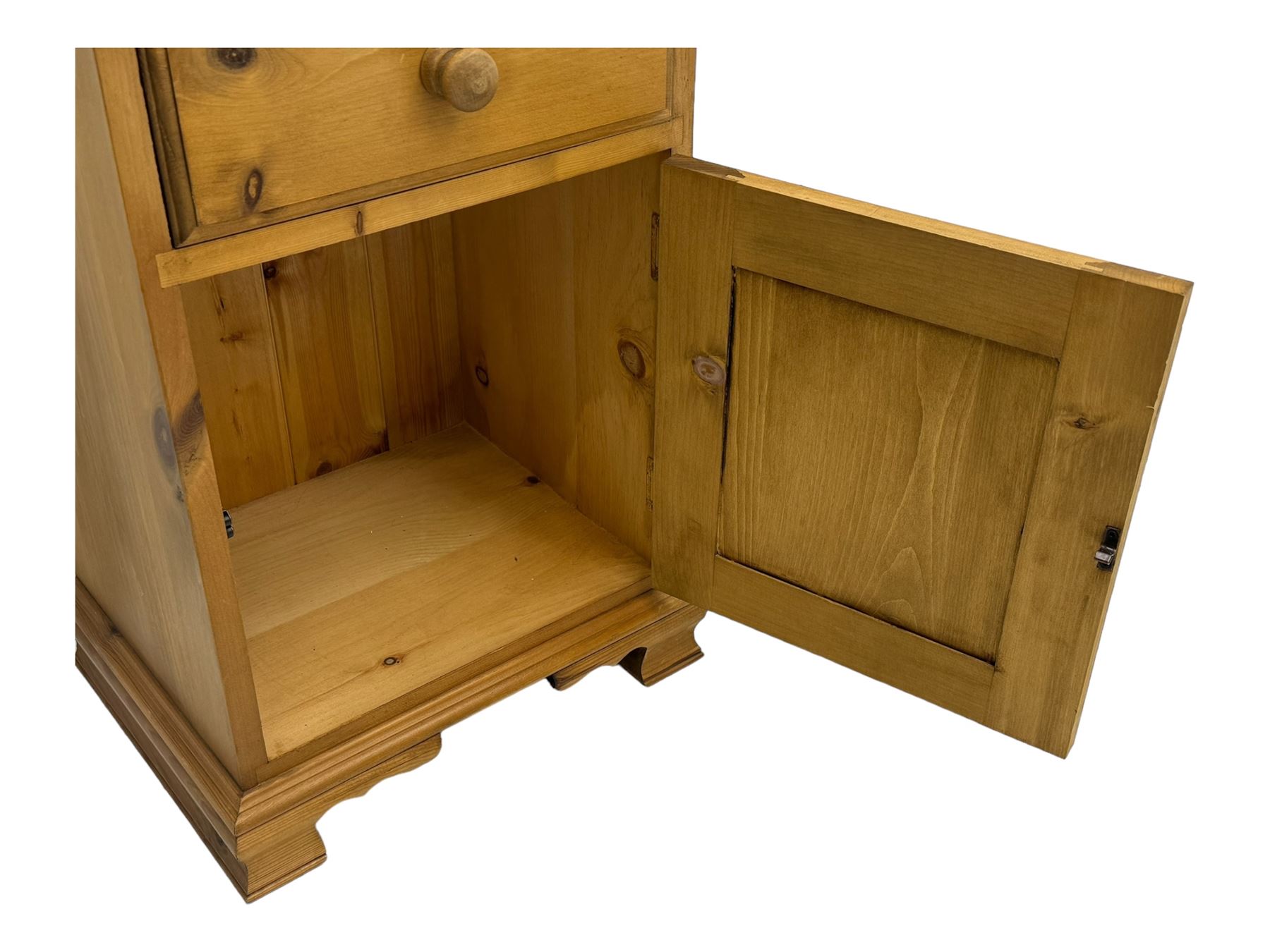 Pine chest of drawers topped with carved pediment with acorn and oak leaf motif, fitted with two short over three long drawers, standing on shaped apron base (W92, D46, H97cm); pine bedside cabinet, single drawer above paneled cupboard door enclosing open storage, shaped plinth base (W43, L32, H67cm)