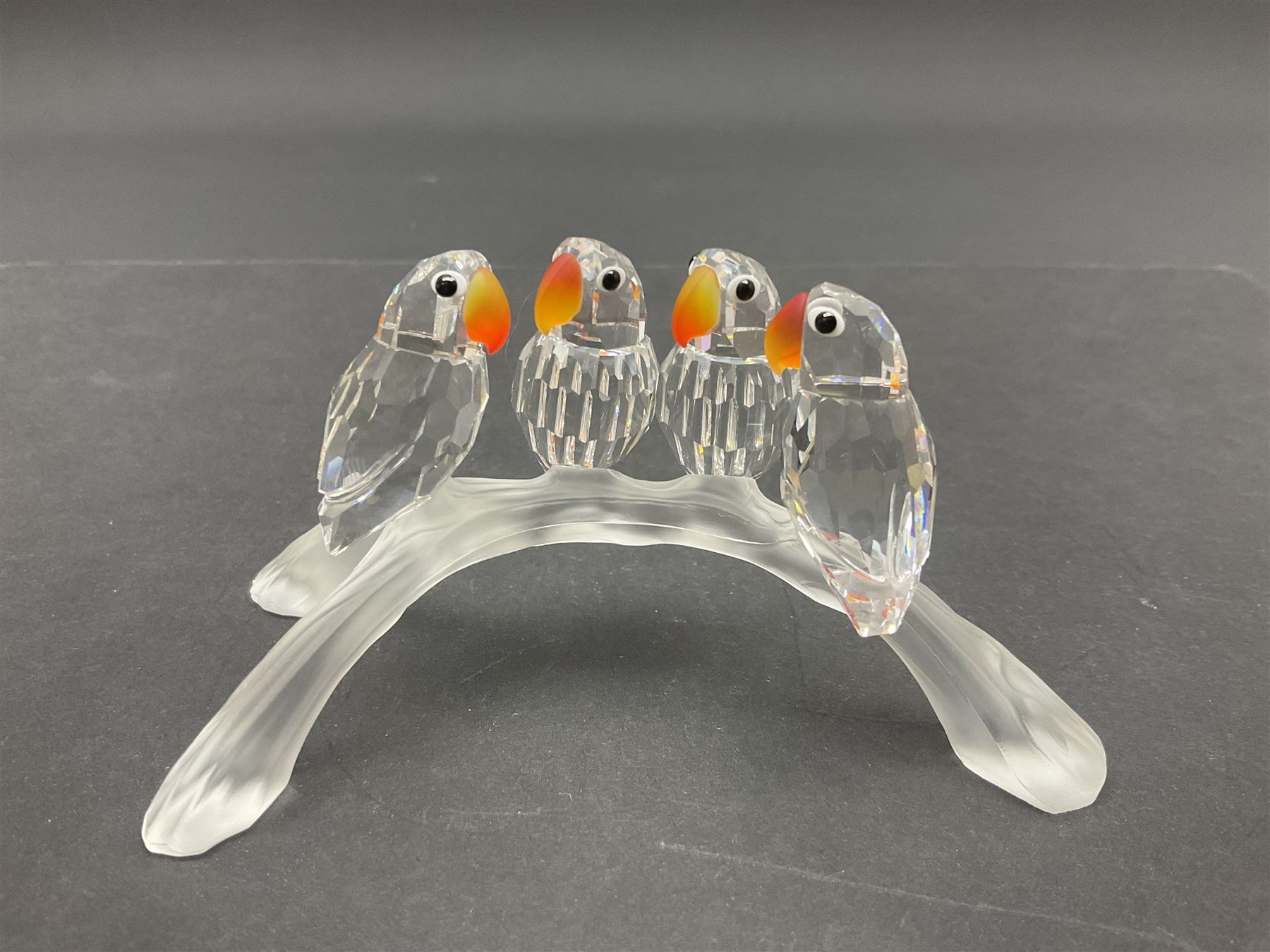 Four Swarovski Crystal bird figures, comprising Cockatoo, pair of Hoopoes on a branch, four Lovebirds on a branch and four Hummingbirds on a branch, largest H10cm