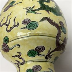 20th century Chinese Famille Verte vase, of slender ovoid form with tapering neck and flared rim, decorated with green and grey enamel with dragons chasing flaming pearls amongst auspicious clouds upon a yellow ground, H30cm