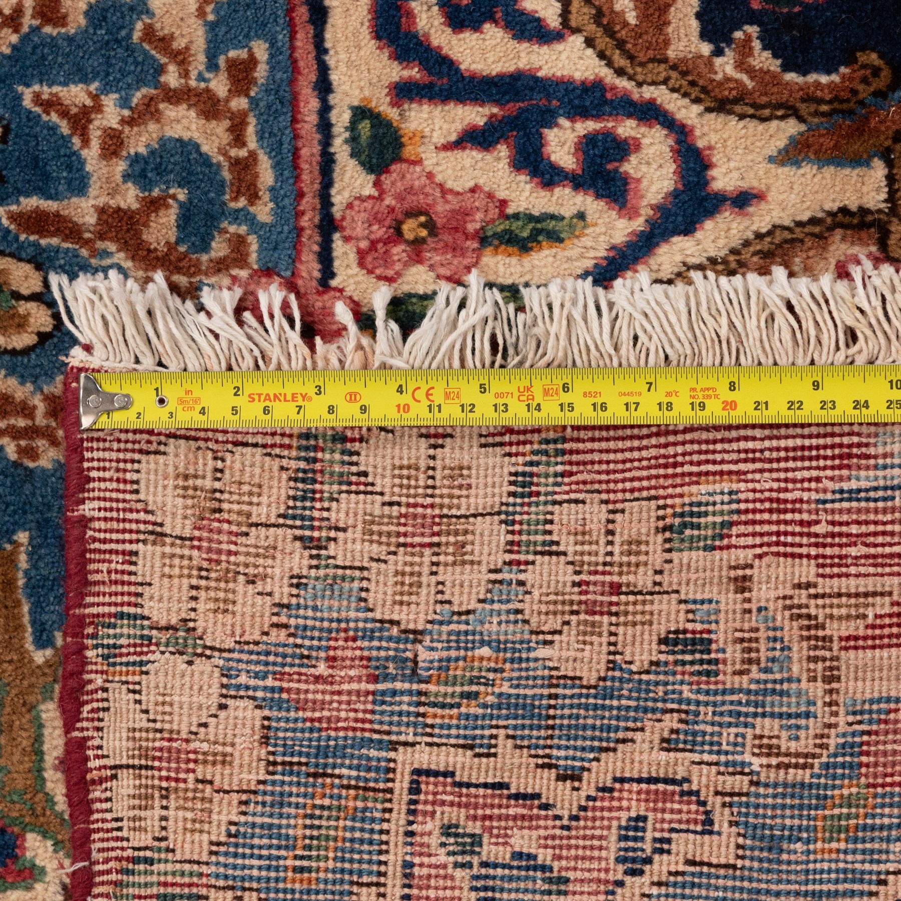 Fine Persian crimson ground Kashan carpet, the busy field with a central floral pole medallion surrounded by bouquets of flowerheads and trailing foliage, the shaped cyan spandrels similarly woven, enclosed by a wide foliate guard band of stylised palmettes and floral designs