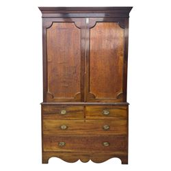 George III mahogany linen press cupboard, projecting moulded cornice over two panelled doors, the interior fitted with two slides and shelf, two short and two long drawers below, shaped apron over bracket feet 