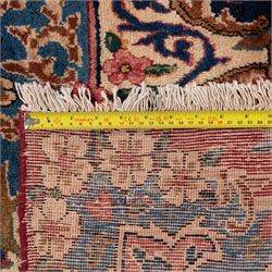 Fine Persian crimson ground Kashan carpet, the busy field with a central floral pole medallion surrounded by bouquets of flowerheads and trailing foliage, the shaped cyan spandrels similarly woven, enclosed by a wide foliate guard band of stylised palmettes and floral designs