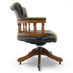 Late 20th century swivel captain’s desk chair, green buttoned vinyl upholstered back and seat with brass stud edging, the spindle gallery over a rotating base with five splayed supports on castors