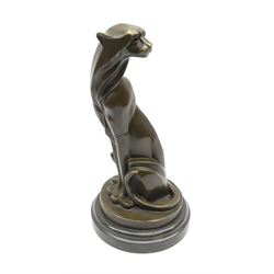 A bronze figure, modelled as a stylised sitting cheetah, signed Milo and with foundry mark, upon a black marble circular stepped base, overall H31.5cm. 