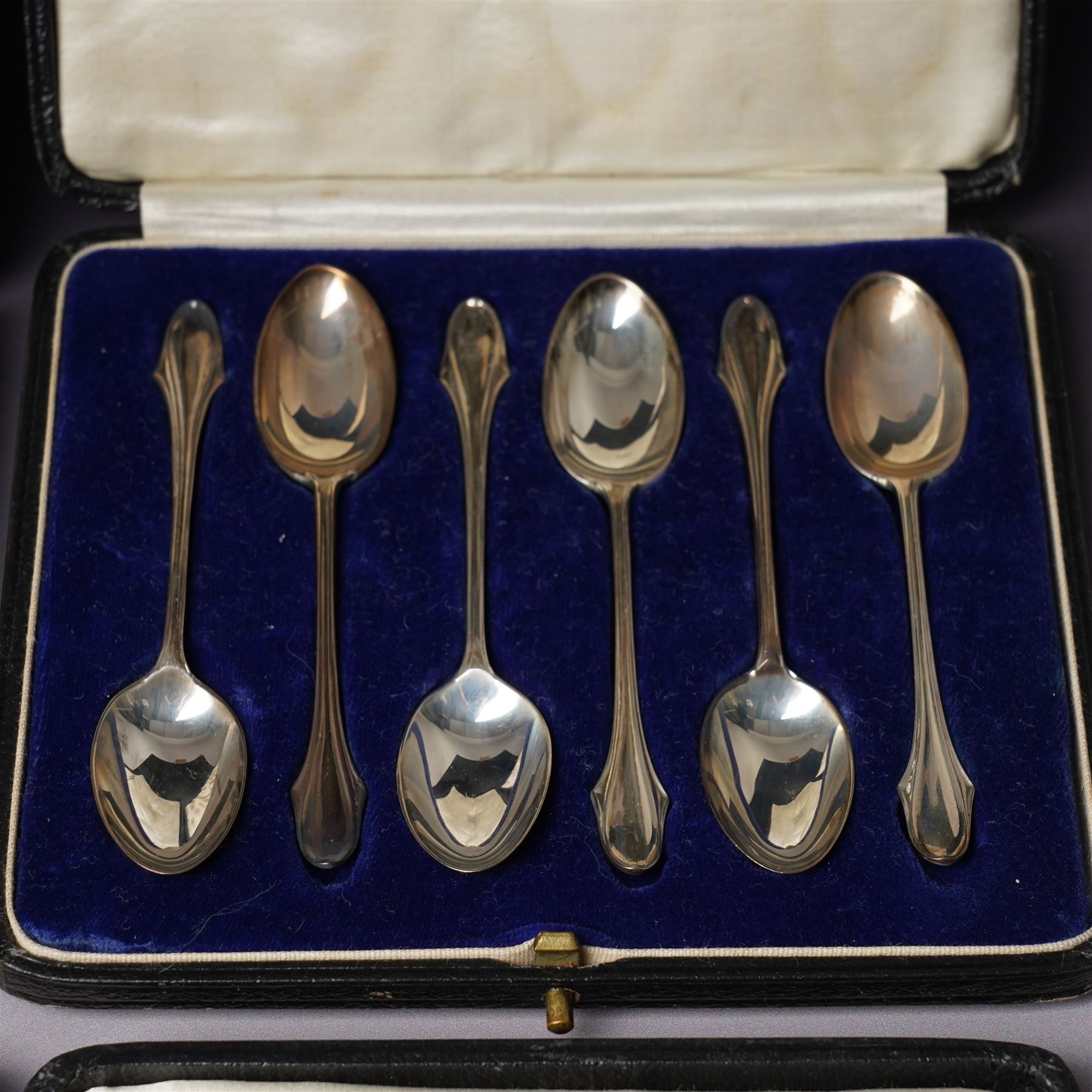 Set of six silver coffee spoons with shaped terminals, cased London 1924, another set of similar spoons London 1924 cased and a set of six silver bead knop spoons Birmingham 1936, cased